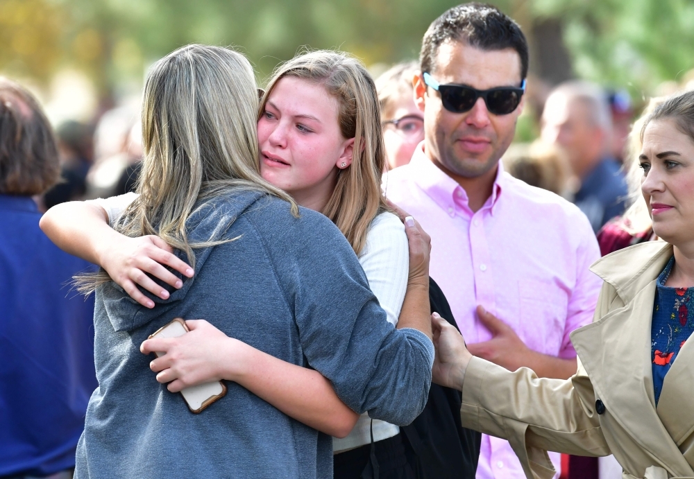 Students and parents embrace after being picked up at Central Park, after a shooting at Saugus High School in Santa Clarita, California on Thursday. — AFP