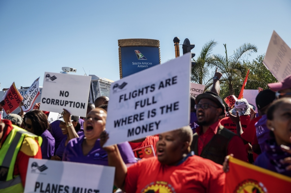 SAA (South African Airways) workers and union members sing and dance during a picket protest outside the O.R. Tambo International Airport in Johannesburg, South Africa, on Friday. The South African airline company has canceled nearly all its domestic, regional and international flights following the strike. — AFP