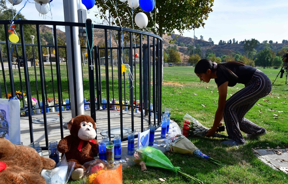 Flowers are placed at a makeshift memorial at Central Park on Friday in Santa Clarita, California, not far from Saugus High School, where parents and children were reunited following the school shooting a day earlier. — AFP