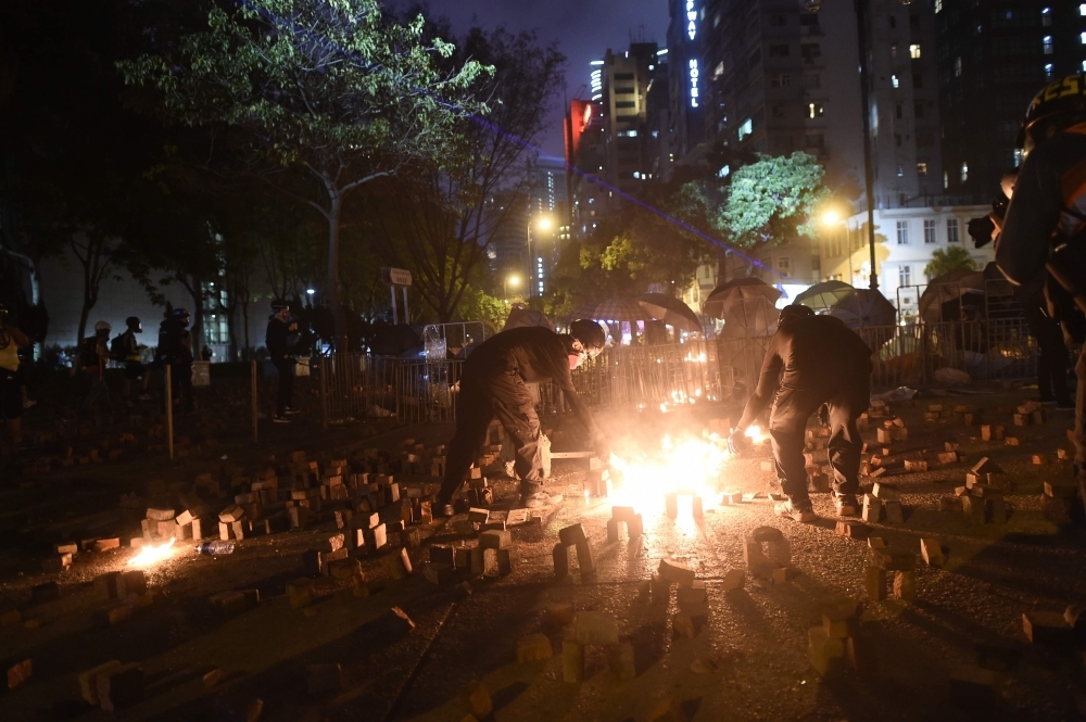 Protestors light up a petrol bomb during clashes with police outside the Polytechnic University of Hong Kong in Hung Hom district of Hong Kong on Saturday. China's President Xi Jinping warned that protests in Hong Kong threaten the 