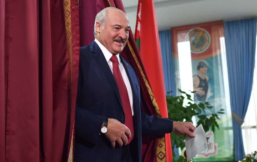 Belarus's President Alexander Lukashenko speaks with journalists as he votes at a polling station during Belarus' parliamentary election in Minsk on Sunday. -AFP