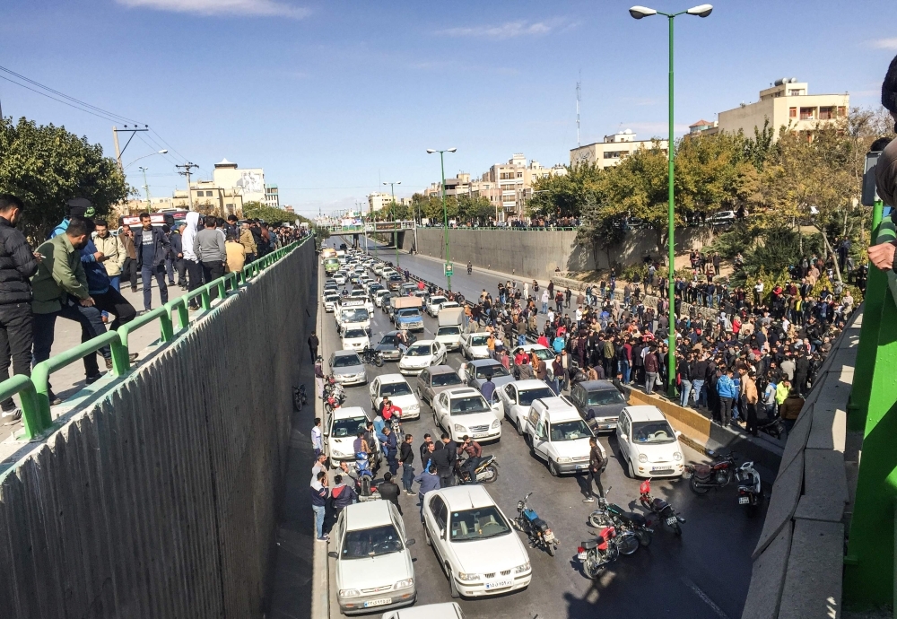 Iranian protesters block a road during a demonstration against an increase in gasoline prices in the central city of Isfahan, on Saturday. — AFP