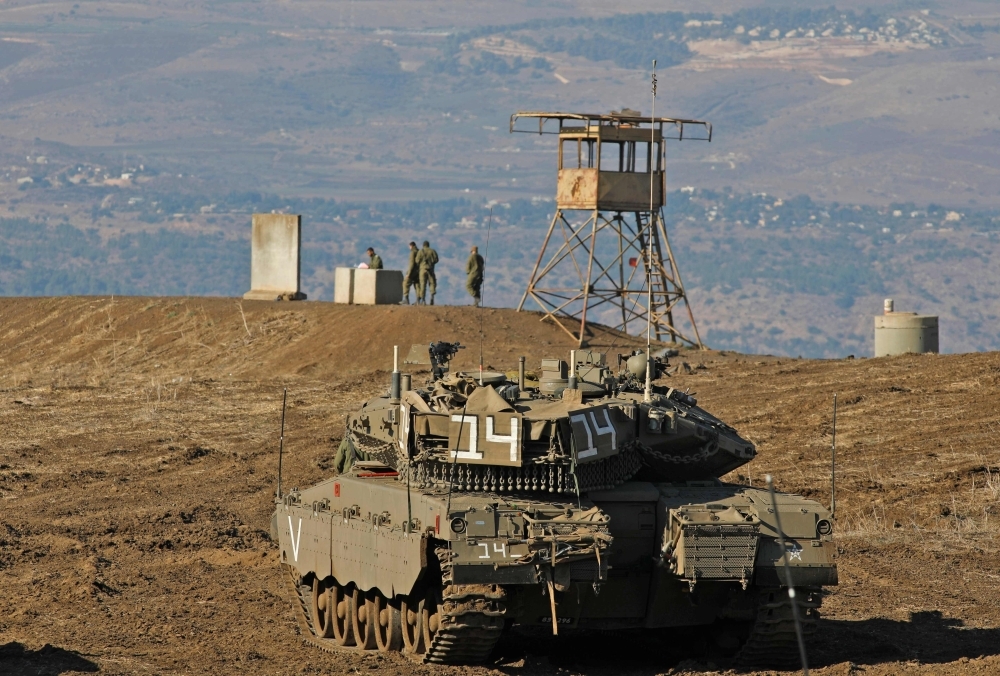 Israeli soldiers and armored vehicles are pictured on Tuesday near the border with Syria in the annexed Golan Heights. -AFP