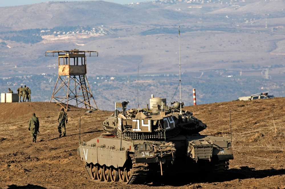 Israeli soldiers and armored vehicles are pictured on Tuesday near the border with Syria in the annexed Golan Heights. -AFP