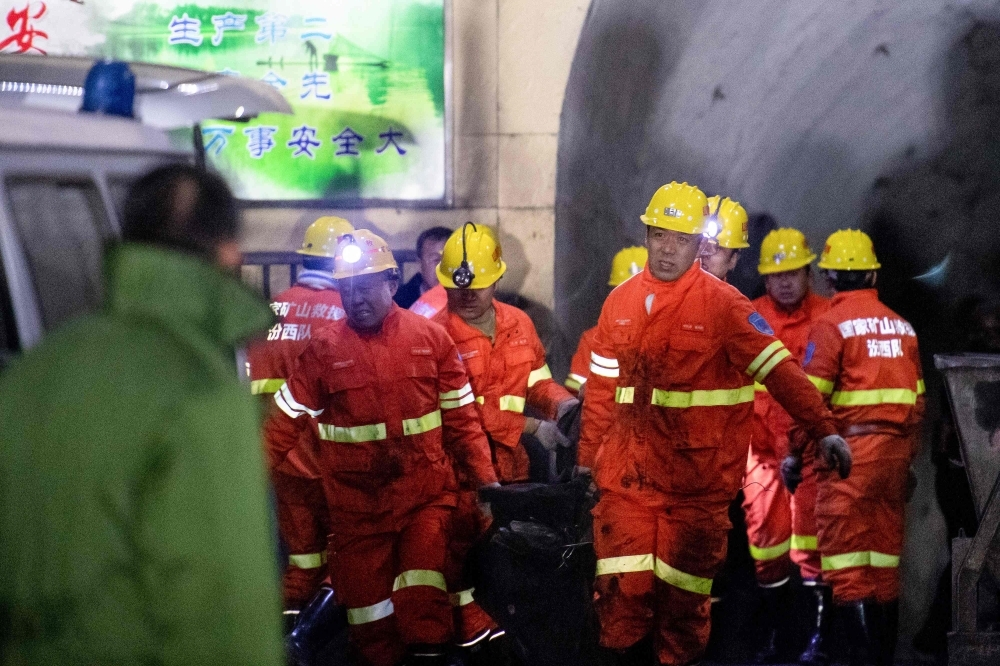 Rescuers carry a victim at the site of a coal mine explosion in Pingyao, in China's northern Shanxi province, early on Tuesday. — AFP