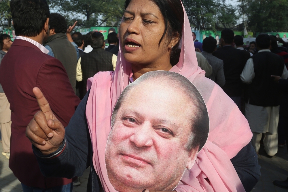 A supporter of Pakistan Muslim League Nawaz (PML-N) holds a cut out picture of the ailing former Pakistani Prime Minister Nawaz Sharif outside his residence before he traveled to Lahore airport prior to his departure for abroad for medical treatment, in Lahore, Pakistan, on Tuesday. — AFP