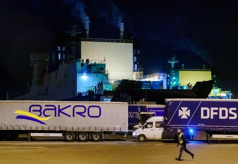 A bus with refugees drives away from the DFDS ferry, in the harbor of Vlaardingen, The Netherlands on Tuesday, after 25 stowaways were found onboard. -AFP