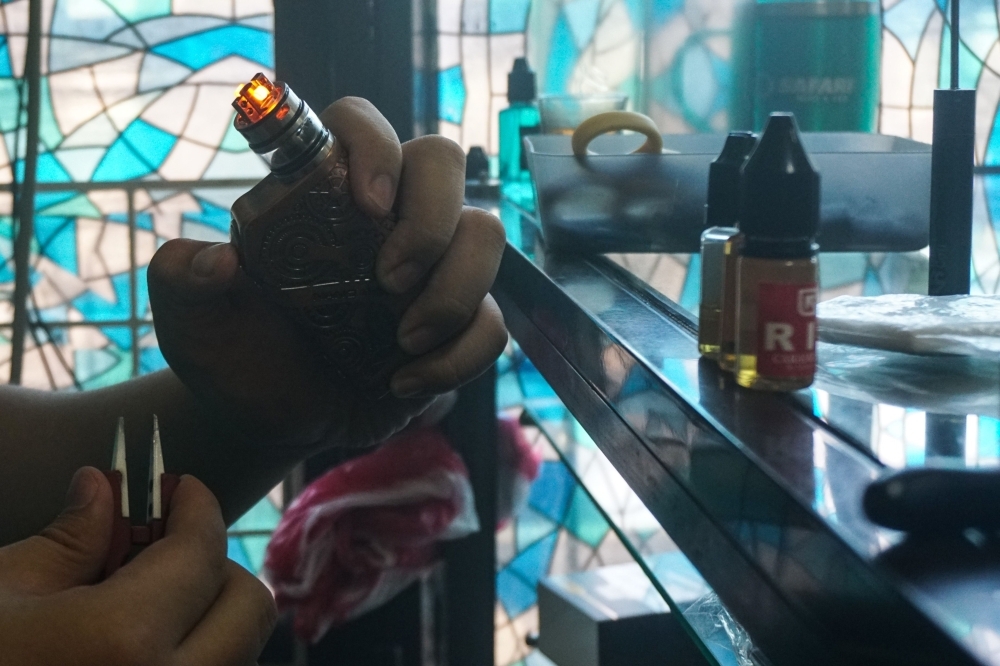  A customer smokes at a vape store in Manila on Wednesday. -AFP
