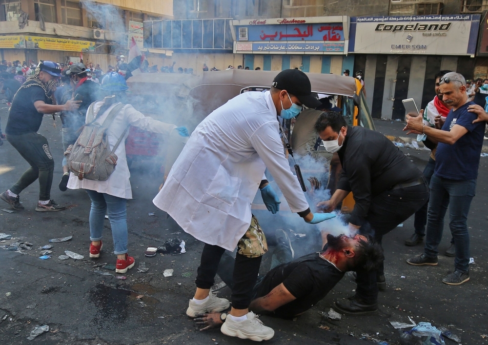 Iraqi protesters carry away an injured comrade amid clashes with riot police during a demonstration against state corruption and poor services, at Baghdad's Tahrir Square in this Oct. 1, 2019 file photo. — AFP