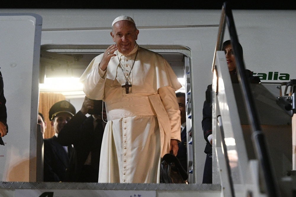 Pope Francis waves as he boards his plane to depart for a one-week trip to Thailand and Japan at Rome's Fiumicino airport on Tuesday. — AFP