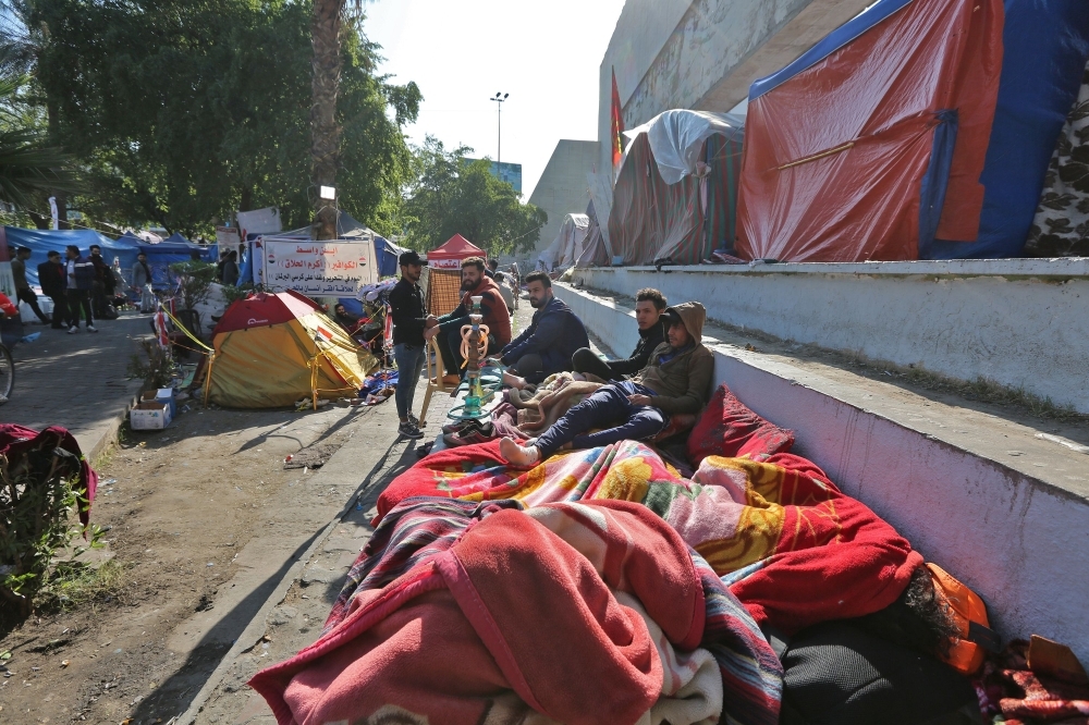 Iraqi anti-government protesters are pictured where they sleep on the side of a road in the Iraqi capital Baghdad's Tahrir square on Wednesday. — AFP