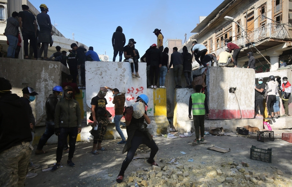 Iraqi anti-government protesters clash with security forces in Al-Rasheed street near Al-Ahrar bridge on Friday. — AFP