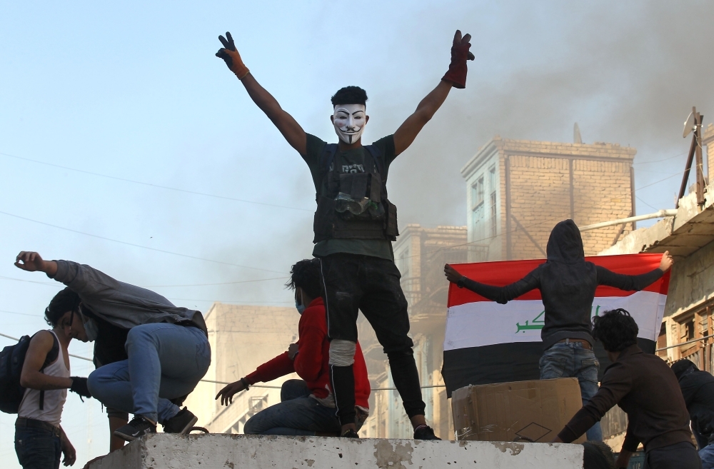 Iraqi anti-government protesters clash with security forces in Al-Rasheed street near Al-Ahrar bridge on Friday. — AFP