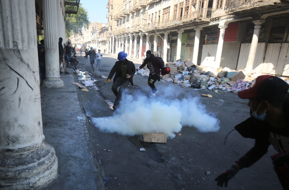 Iraqi anti-government protesters clash with security forces in Al-Rasheed street near Al-Ahrar bridge on Friday. — AFP