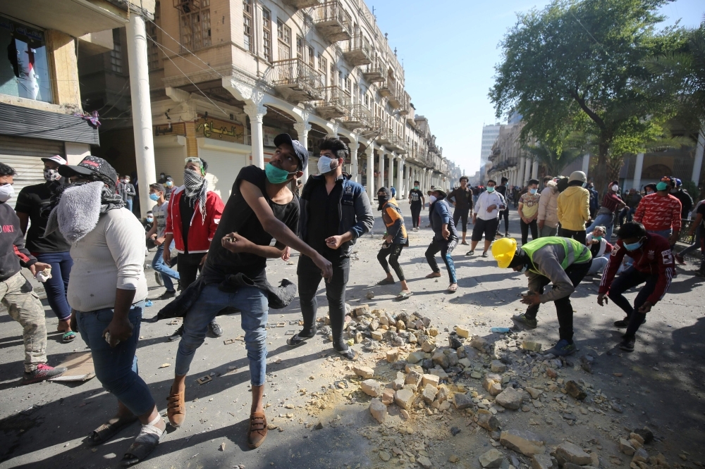 Iraqi anti-government protesters clash with security forces in Al-Rasheed street near Al-Ahrar bridge on Friday. — AFP