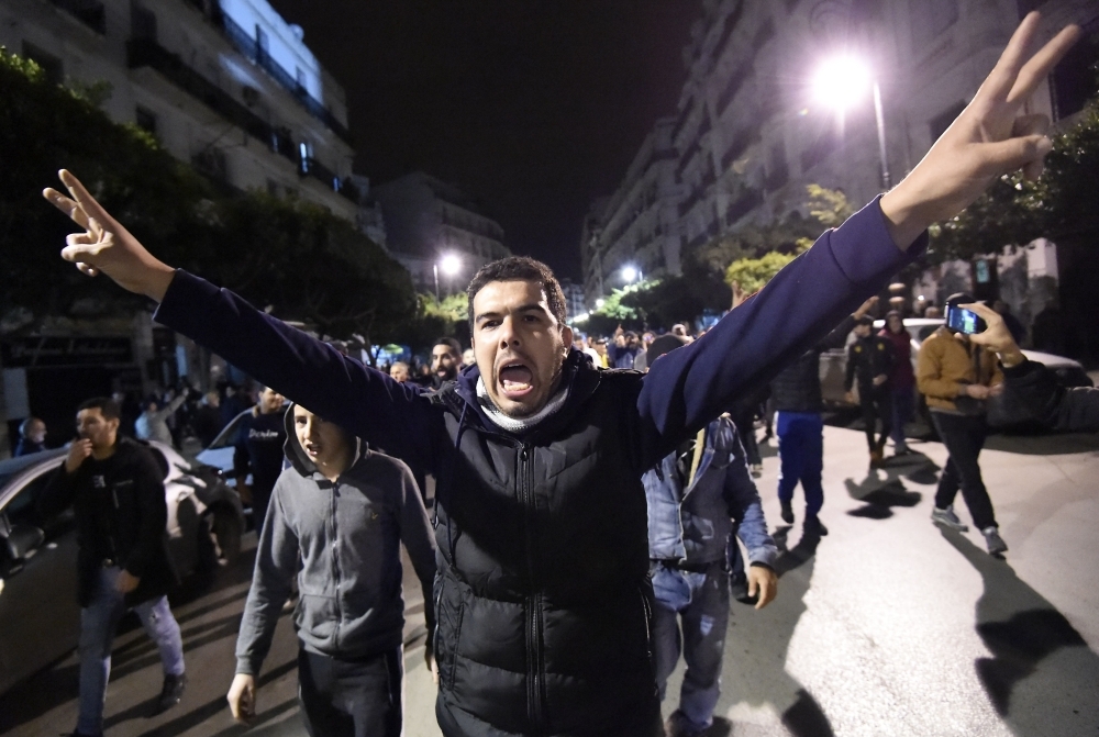 Algerians shout slogans and march in the streets of the capital Algiers as they participate in a night demonstration against the upcoming presidential election on Thursday. — AFP