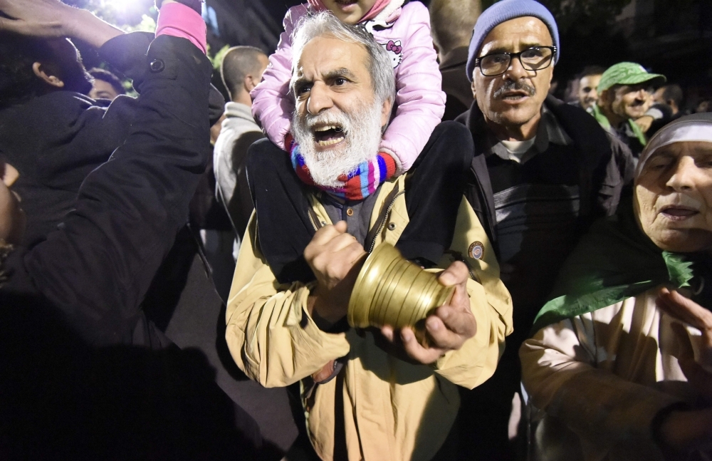 Algerians shout slogans and march in the streets of the capital Algiers as they participate in a night demonstration against the upcoming presidential election on Thursday. — AFP