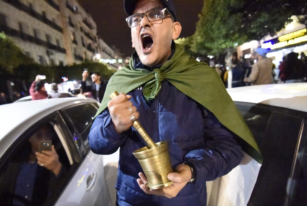 Algerians shout slogans and march in the streets of the capital Algiers as they participate in a night demonstration against the upcoming presidential election on Thursday. — AFP