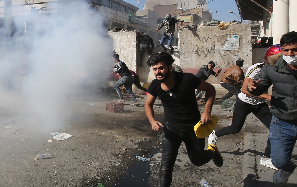 Iraqi anti-government protesters clash with security forces in Al-Rasheed street near Al-Ahrar bridge on Friday. — AFP