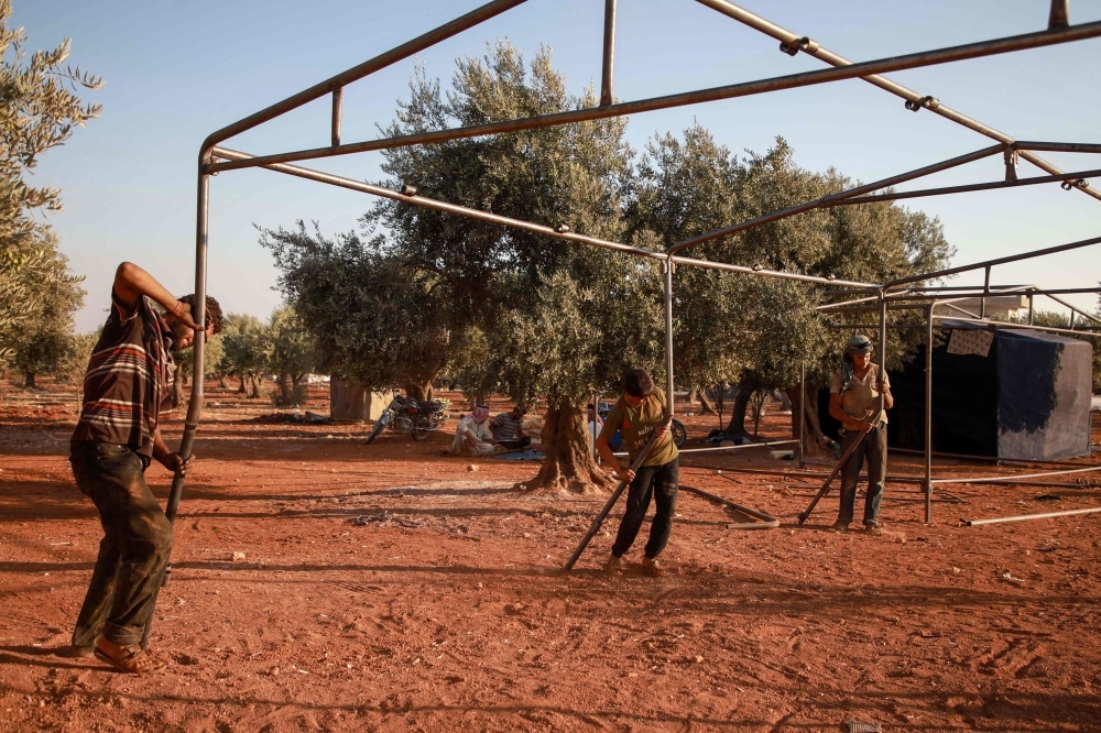 Jumaa Al-Mustayf welds metal pipes at a camp for the displaced near the town of Hazzanu, about 20 kilometers northwest of the city of Idlib, on September 30, 2019. -AFP