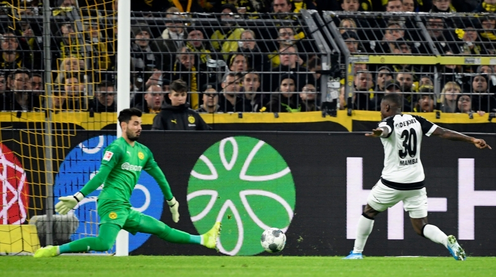 Paderborn's German forward Streli Mamba (R) scores the 0-1 against Dortmund's Swiss goalkeeper Roman Buerki during the German first division Bundesliga football match Borussia Dortmund v SC Paderborn in Dortmund, western Germany, on Friday. — AFP
