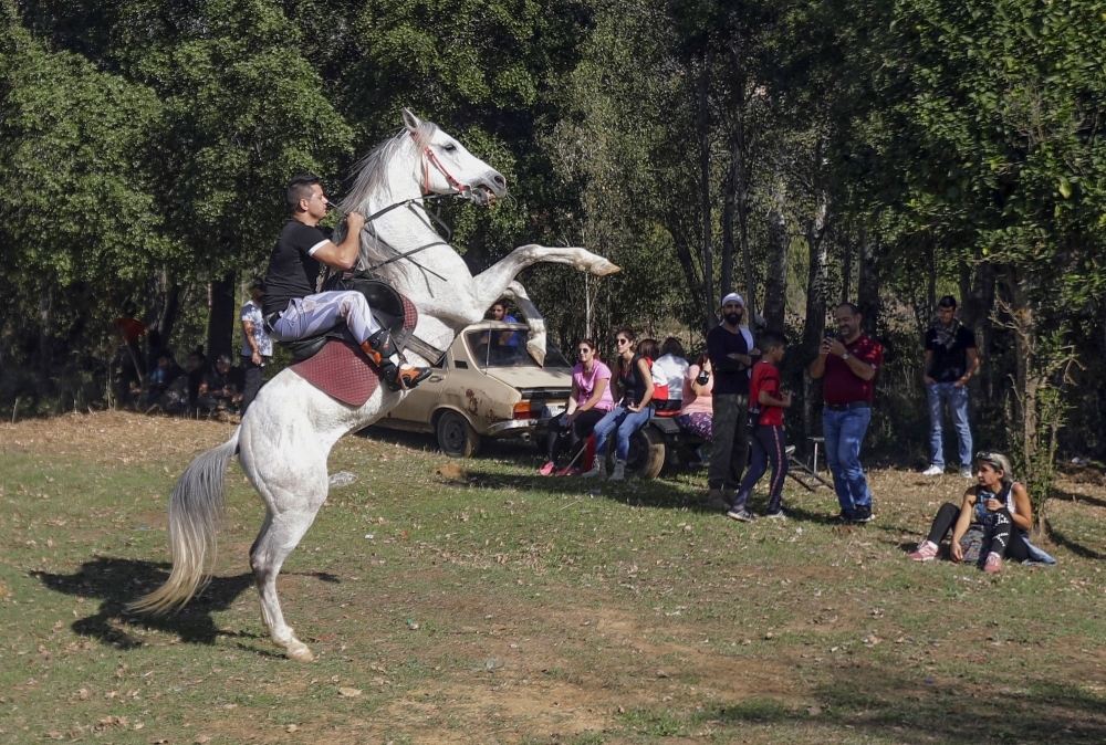 A young Lebanese man rides a horse as protesters take a break during a 20km march in the Bisri Valley, southwest of the capital Beirut on November 22, 2019, to protest against the construction of a dam in the area. -AFP
