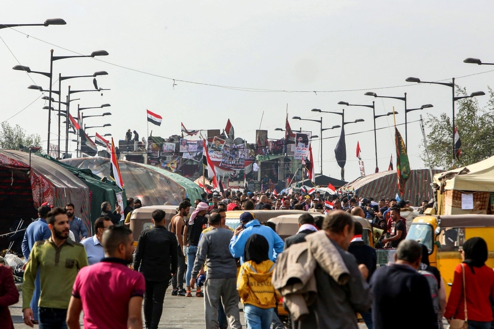 Smoke billows from burning tires during a demonstration in the southern city of Basra on Sunday, as protesters cut-off roads and activists call for a general strike. -AFP