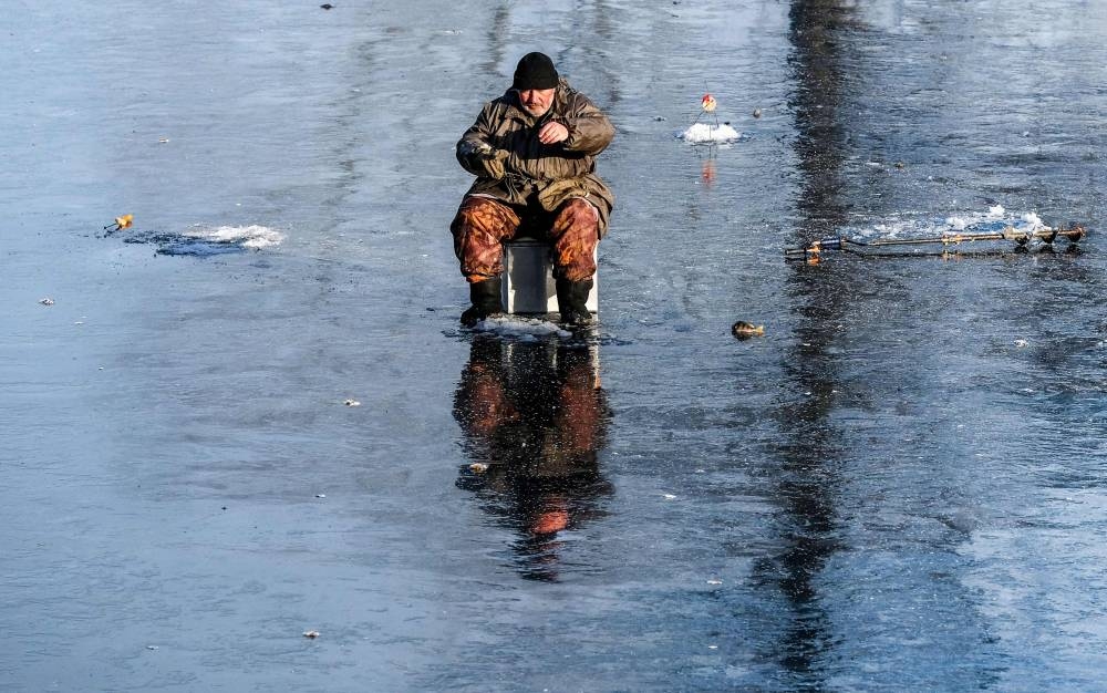 Fishing on ice of a frozen pond