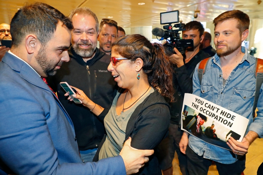 American citizen Omar Shakir, center, the director of the New York-based Human Rights Watch for Israel and the Palestinian territories, delivers a speech at Ben Gurion airport on Monday, after being expelled from Israel. — AFP