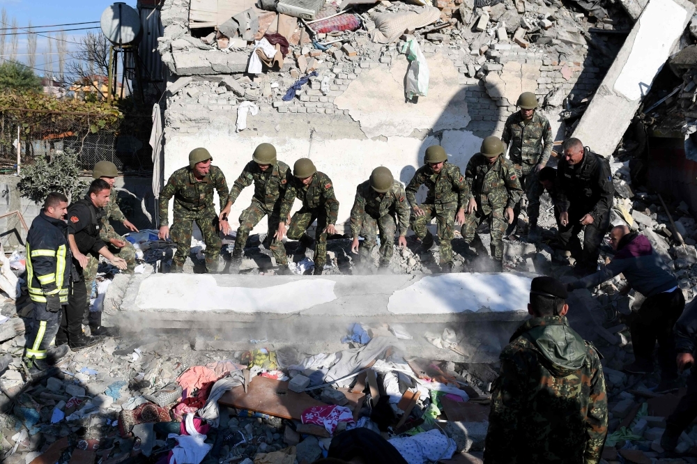 Emergency workers clear debris at a damaged building in Thumane, 34 km (about 20 miles) northwest of capital Tirana, after an earthquake hit Albania, on Tuesday. — AFP