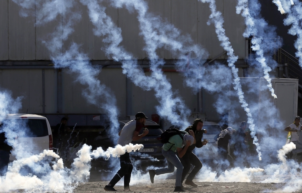 A Palestinian protester holds up a placard in the West Bank city of Ramallah on Tuesday as Palestinians stage a 