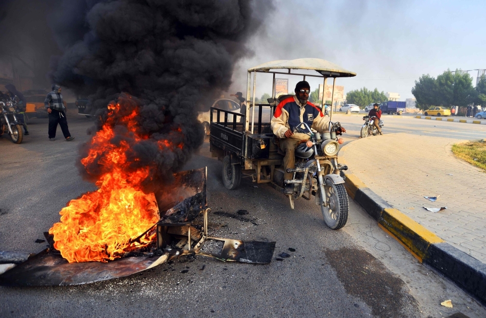 Iraqi demonstrators help an injured youth during clashes with security forces in the capital Baghdad's Al-Rasheed street near Al-Ahrar bridge on Tuesday. -AFP