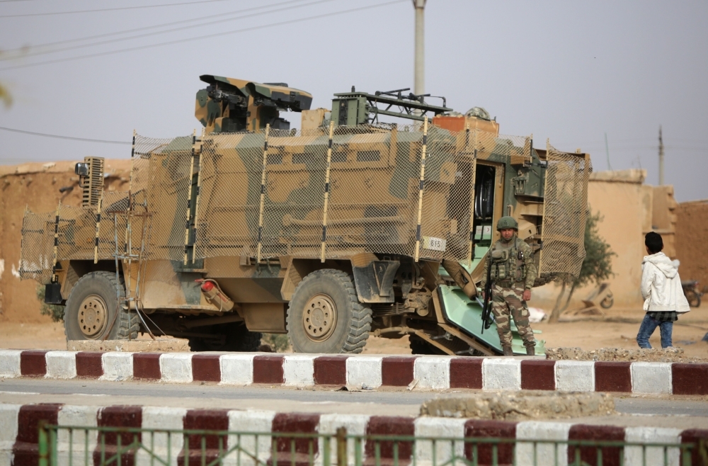 A Turkish soldier stands near his armored vehicle on a highway near the northern Syrian town of Ain Issa in Idlib province on Tuesday. — AFP