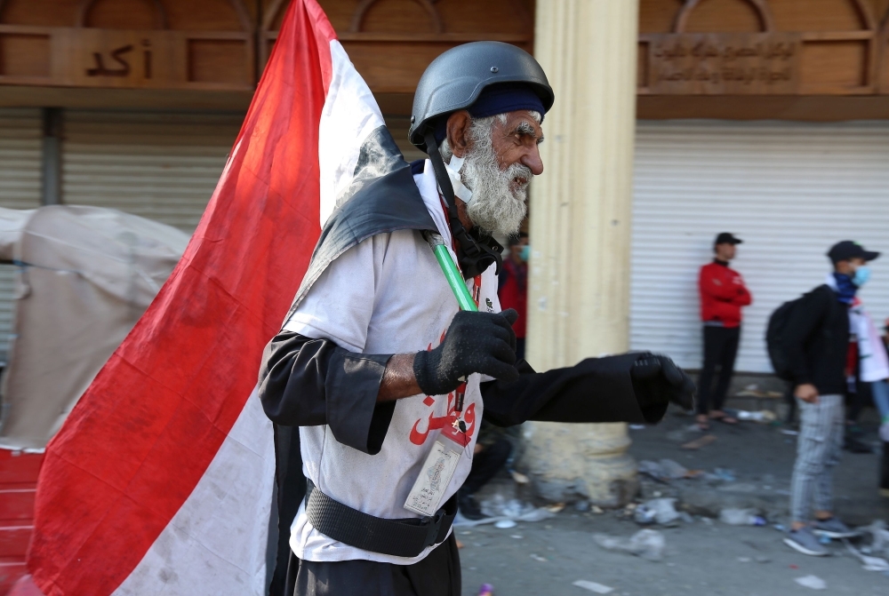 Iraqi demonstrators help an injured youth on Al-Rashid street in the capital Baghdad, amid ongoing anti-government protests, on Wednesday. — AFP