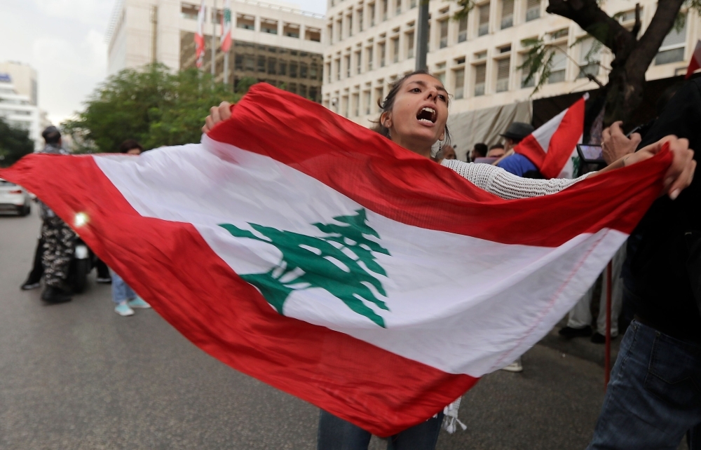 A Lebanese anti-government protester hold a mask of Lebanon's Central Bank Governor Riad Salameh during a protest in front of the central bank headquarters in Beirut to protest against the economic policies of the bank on Wednesday. — AFP