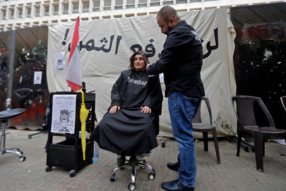 A Lebanese anti-government protester hold a mask of Lebanon's Central Bank Governor Riad Salameh during a protest in front of the central bank headquarters in Beirut to protest against the economic policies of the bank on Wednesday. — AFP