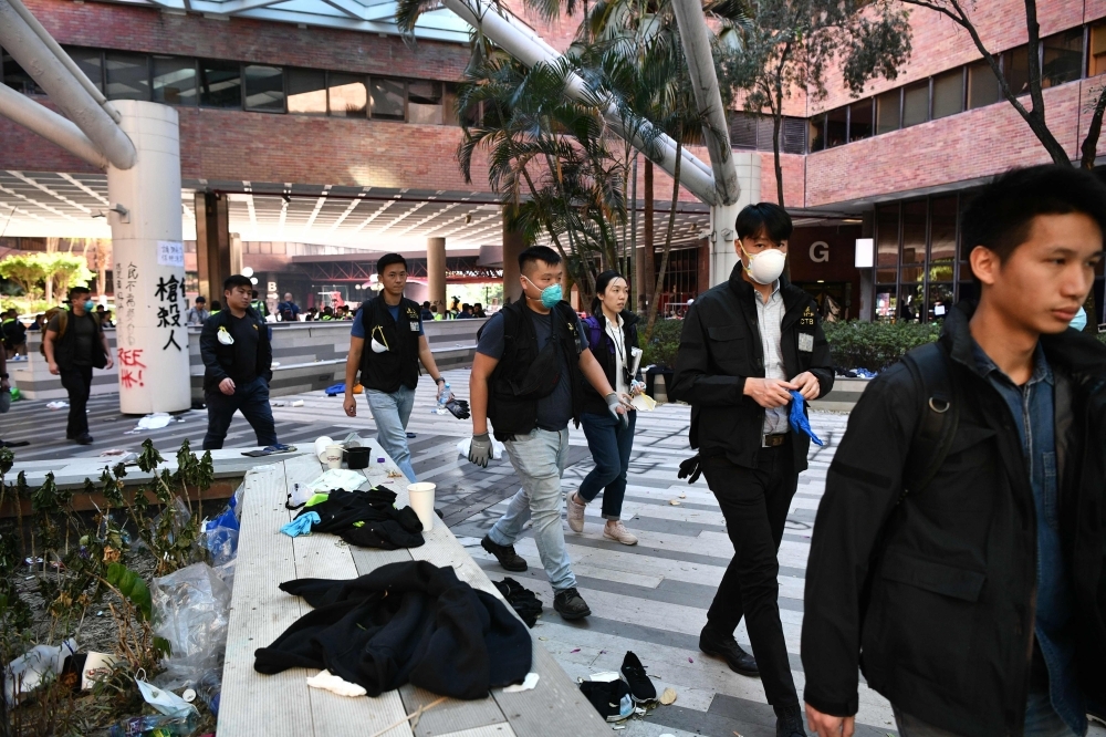 Police walk on the campus of the Hong Kong Polytechnic University in the Hung Hom district of Hong Kong on Thursday, over a week after police surrounded the building while pro-democracy protesters were still barricaded inside. — AFP