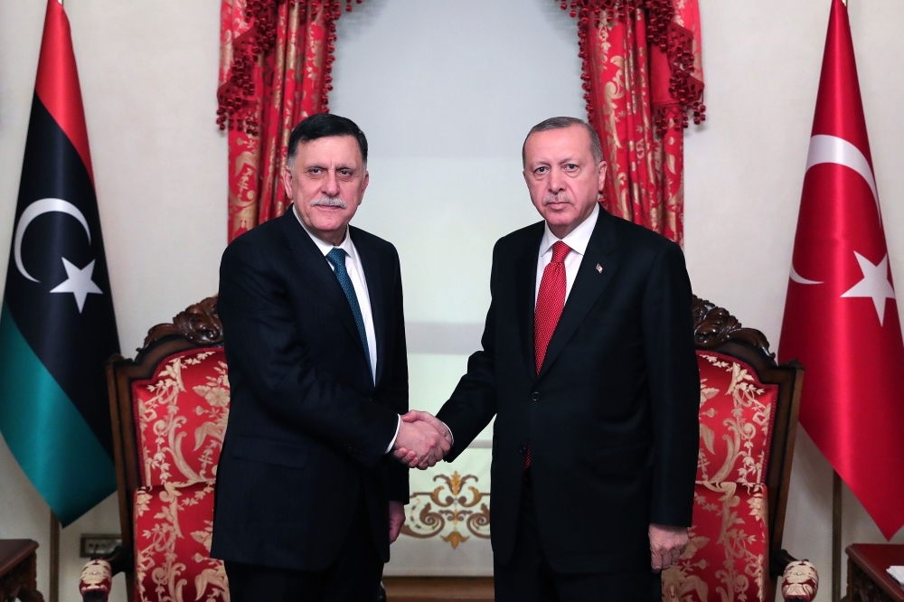 Turkish President Recep Tayyip Erdogan, right, shakes hands with Fayez Al-Sarraj, the head of the Tripoli-based Government of National Accord (GNA), during their meeting in Istanbul, on Wednesday. — AFP