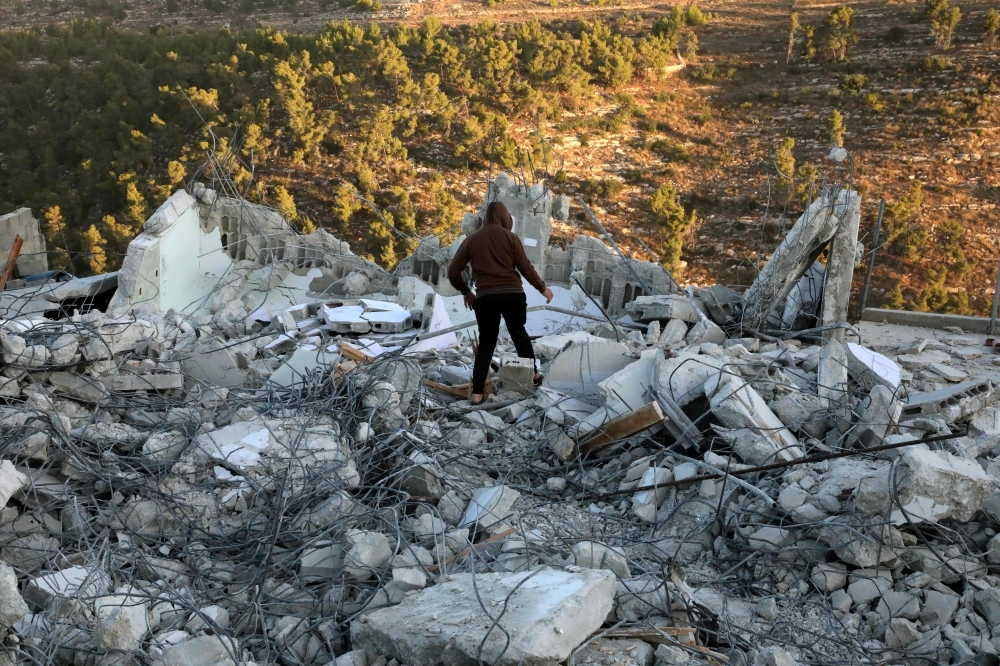 Palestinians check the house of a man who reportedly carried out an attack against Israelis in August, after it was demolished by Israeli authorities in the village of Beit Kahel near the West Bank town of Hebron, on Thursday. — AFP