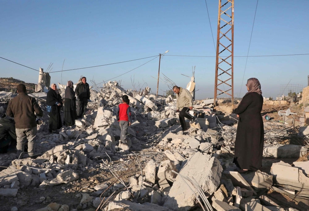 Palestinians check the house of a man who reportedly carried out an attack against Israelis in August, after it was demolished by Israeli authorities in the village of Beit Kahel near the West Bank town of Hebron, on Thursday. — AFP