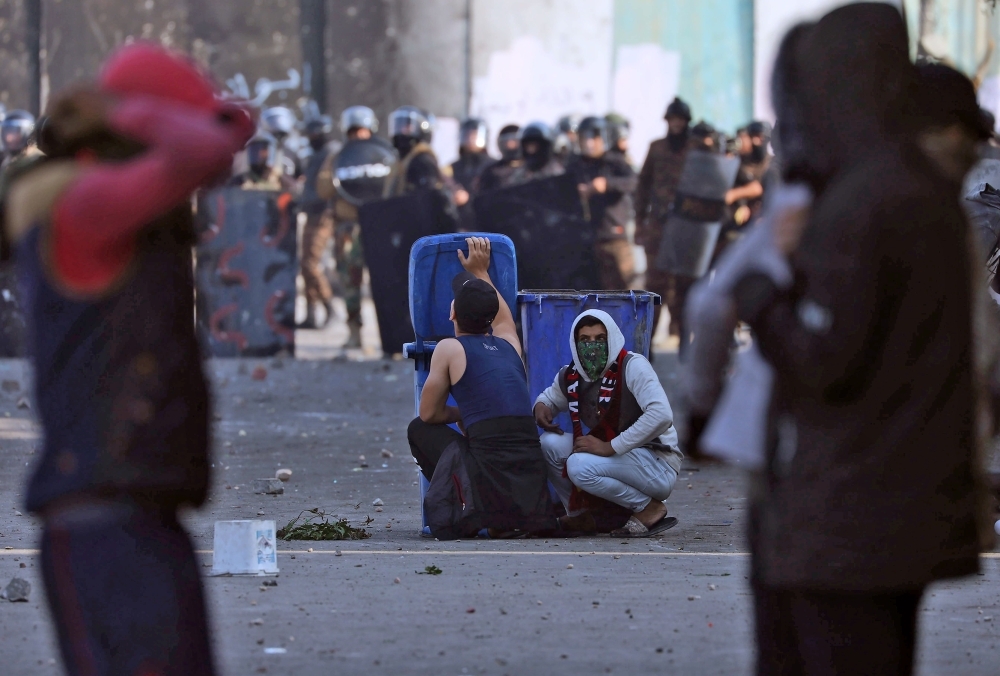 Iraqi protesters clash with Iraqi security forces in Al-Rasheed Street in Baghdad during ongoing anti-government demonstrations against corruption on Thursday. — AFP