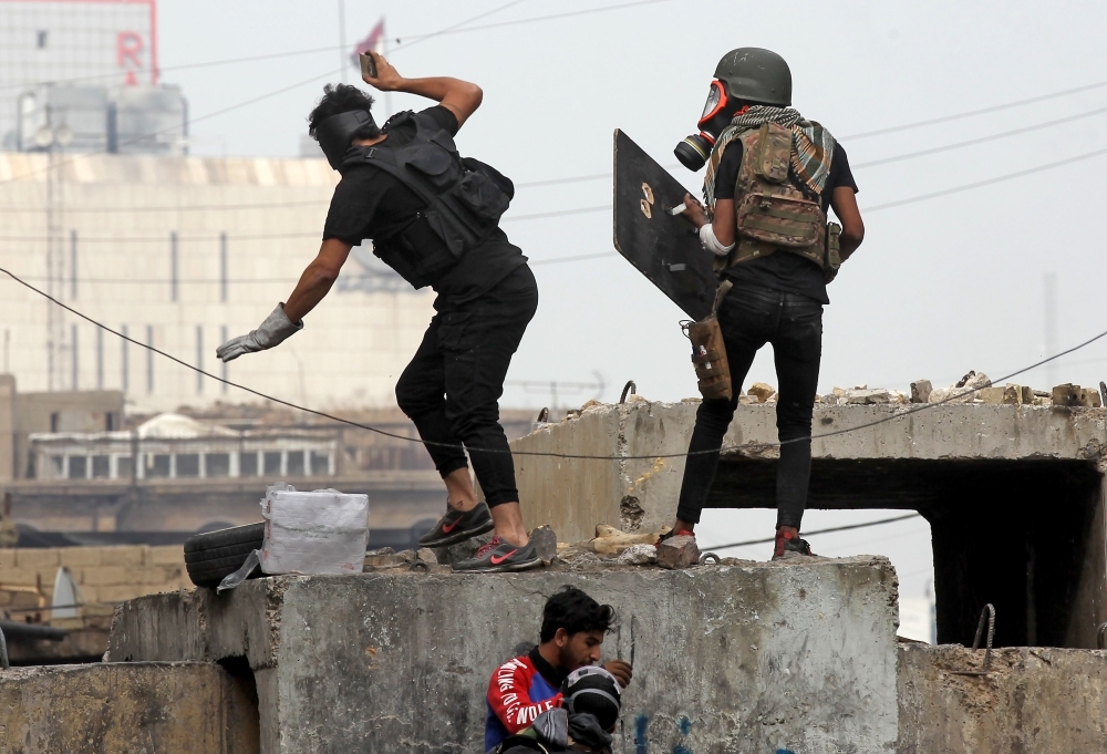 Iraqi protesters clash with Iraqi security forces in Al-Rasheed Street in Baghdad during ongoing anti-government demonstrations against corruption on Thursday. — AFP