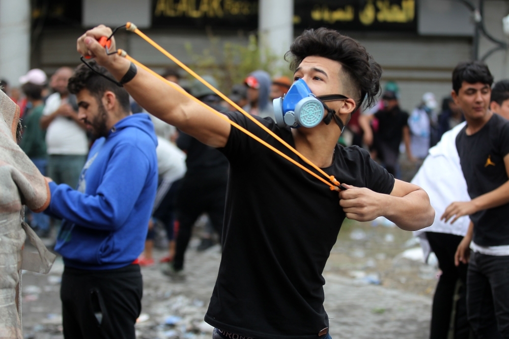 Iraqi protesters clash with Iraqi security forces in Al-Rasheed Street in Baghdad during ongoing anti-government demonstrations against corruption on Thursday. — AFP