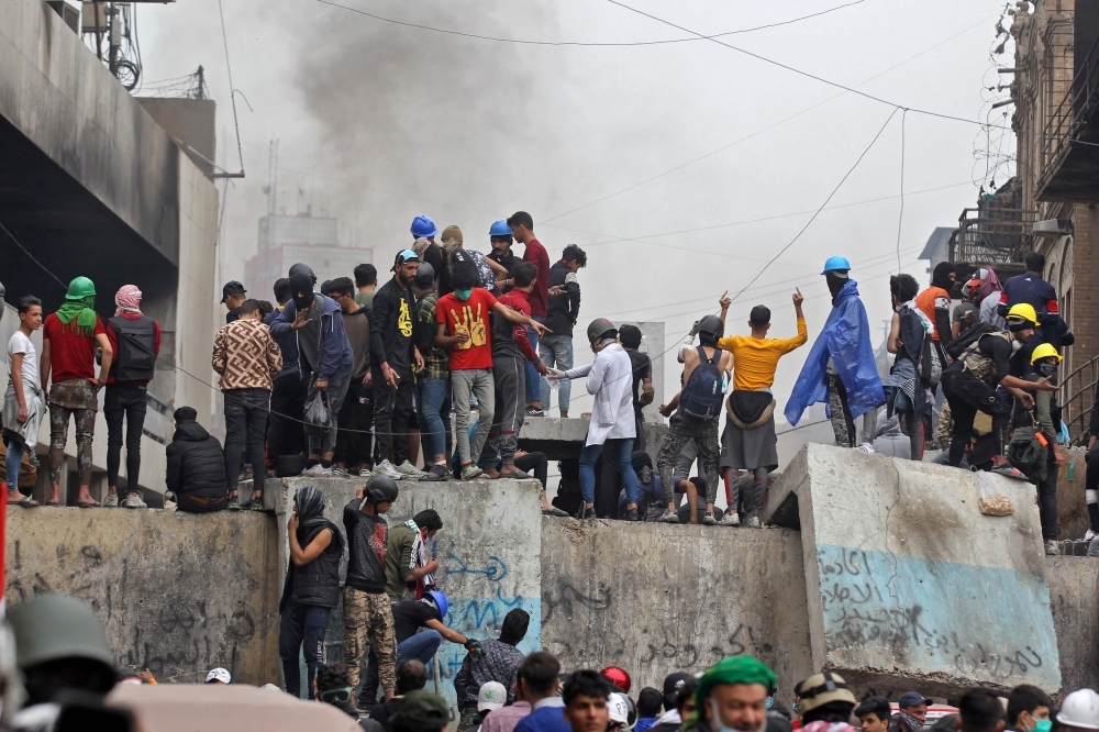 Iraqi protesters clash with Iraqi security forces in Al-Rasheed Street in Baghdad during ongoing anti-government demonstrations against corruption on Thursday. — AFP