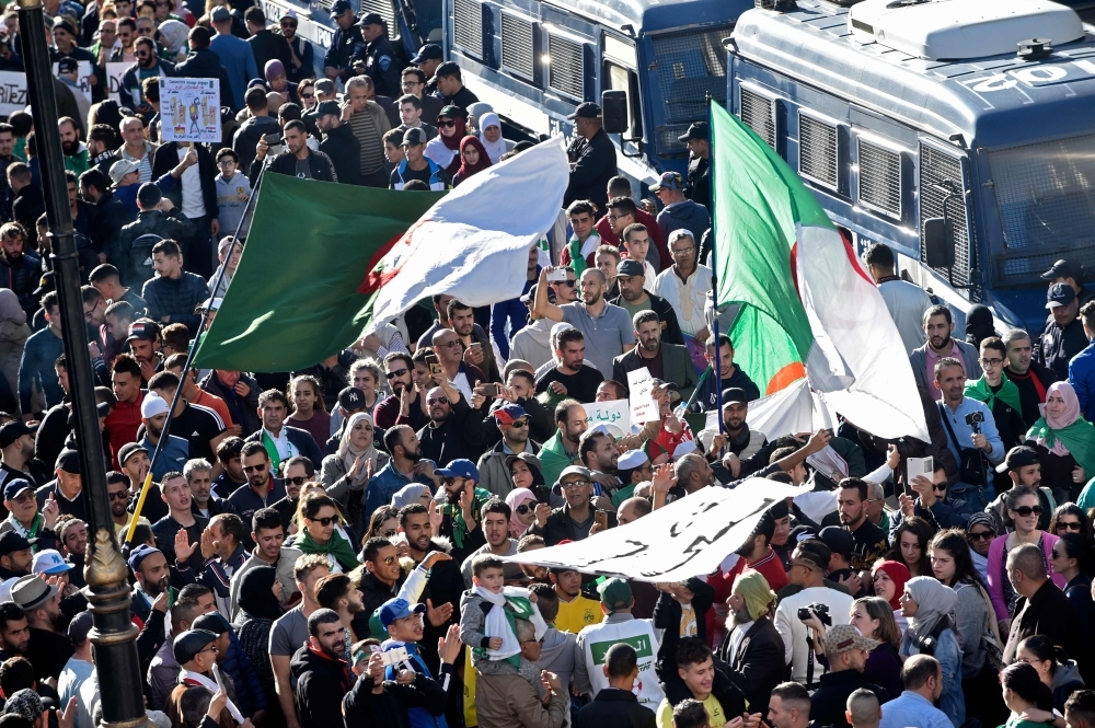 Algerian demonstrators wave national flags as they gather on the 41st consecutive Friday demonstration against the government and the ruling class in the capital Algiers on Friday. — AFP