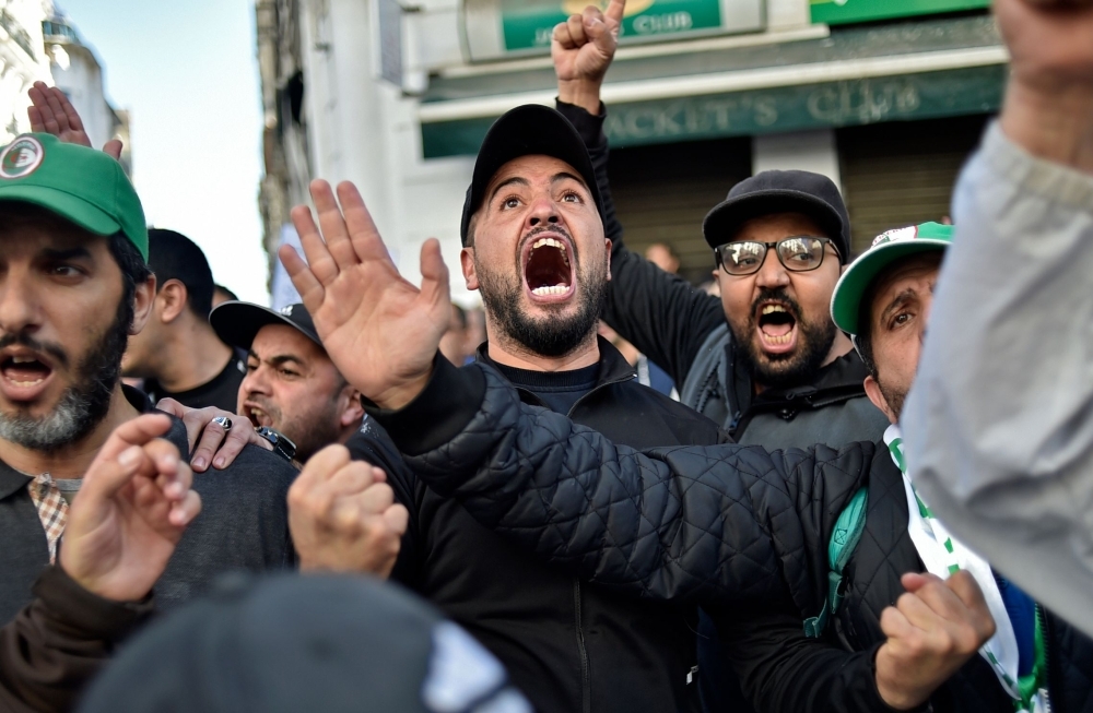 Algerian demonstrators wave national flags as they gather on the 41st consecutive Friday demonstration against the government and the ruling class in the capital Algiers on Friday. — AFP