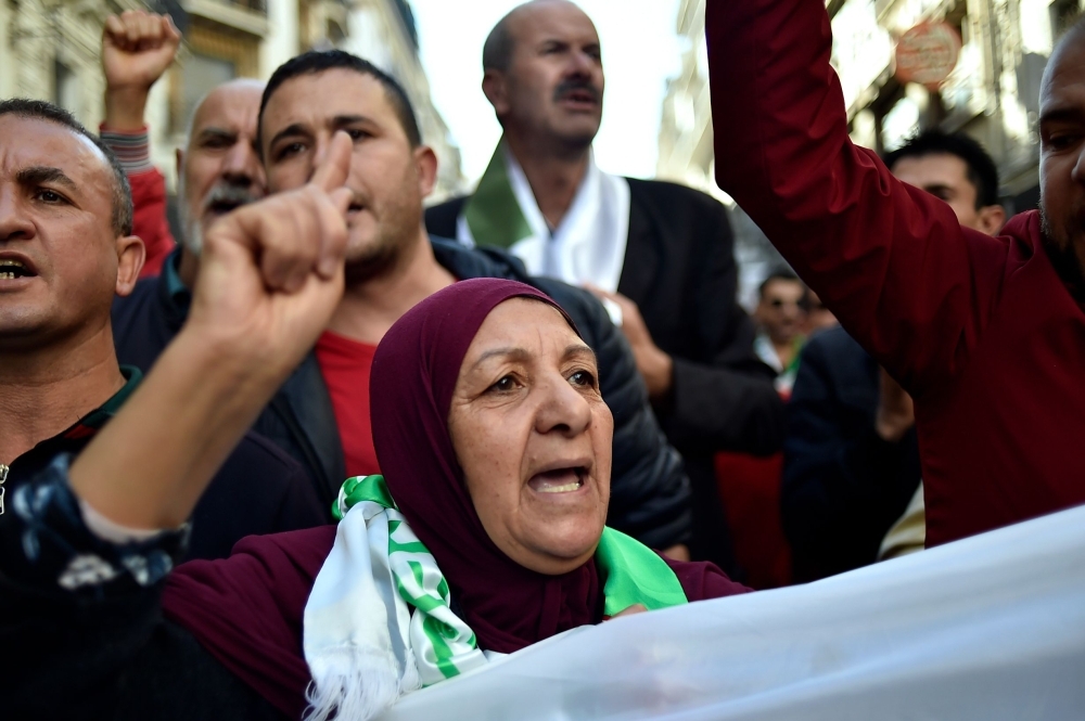 Algerian demonstrators wave national flags as they gather on the 41st consecutive Friday demonstration against the government and the ruling class in the capital Algiers on Friday. — AFP