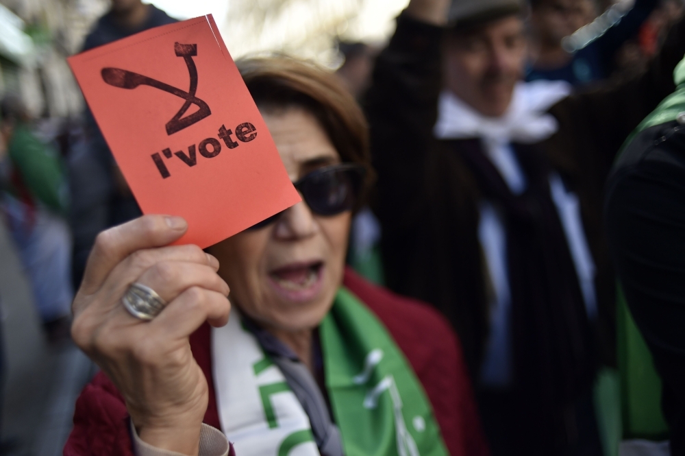 Algerian demonstrators wave national flags as they gather on the 41st consecutive Friday demonstration against the government and the ruling class in the capital Algiers on Friday. — AFP
