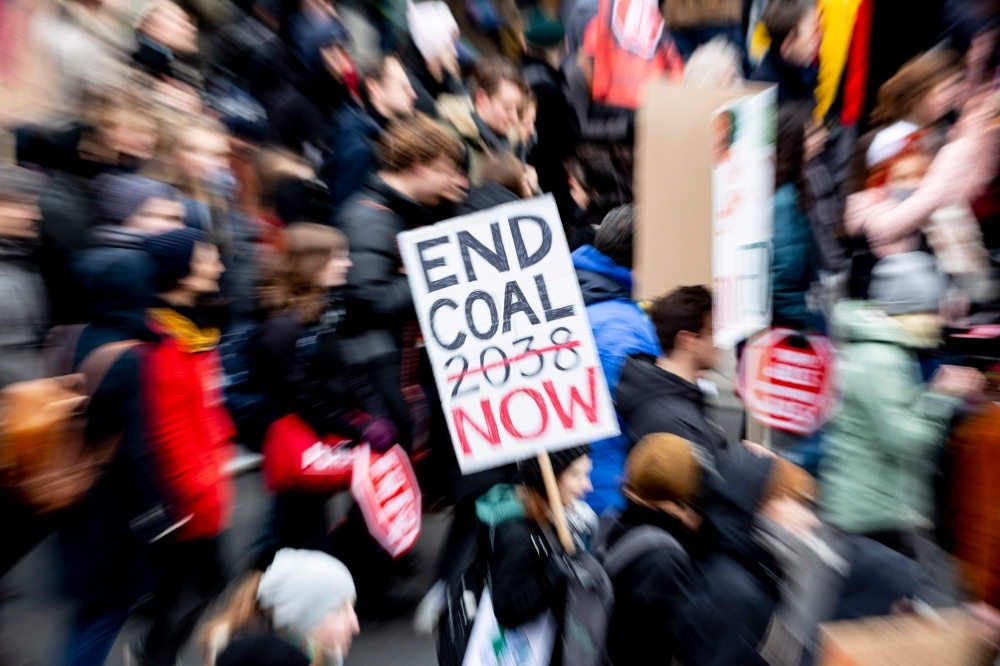A demonstrator walks with a placard during a protest called by the Fridays for Future movement for climate protection on Friday in Berlin, as part of global action day for climate.  -AFP
 / AFP / dpa / Christoph Soeder