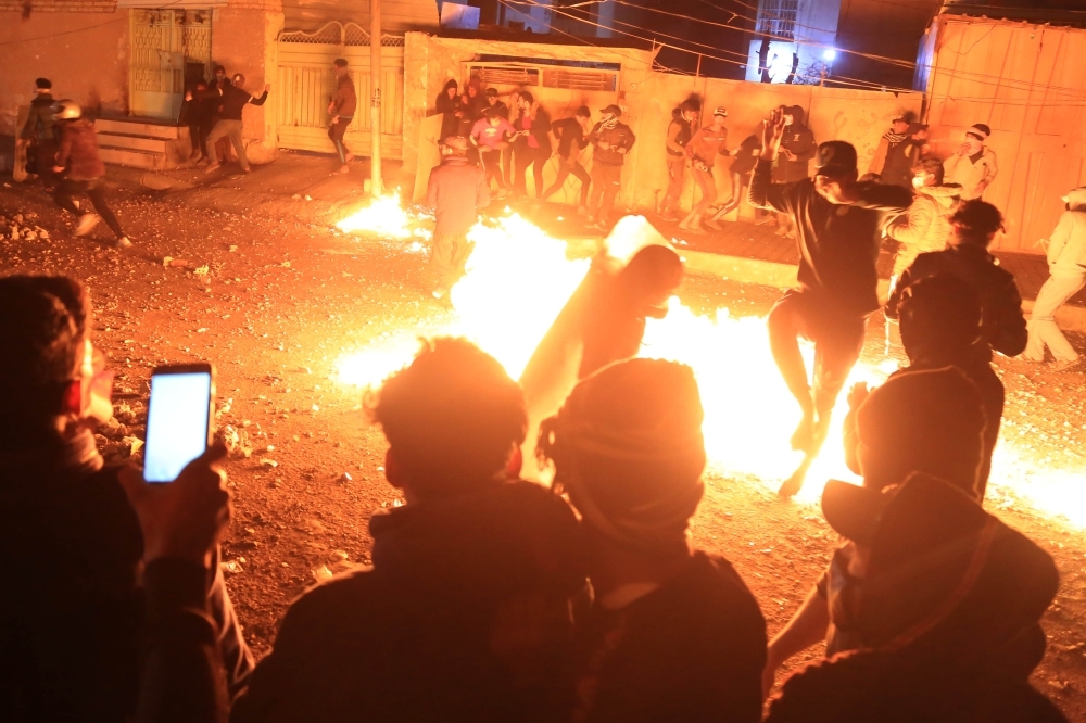 Iraqi demonstrators clash with security forces in Karbala on Friday. -AFP